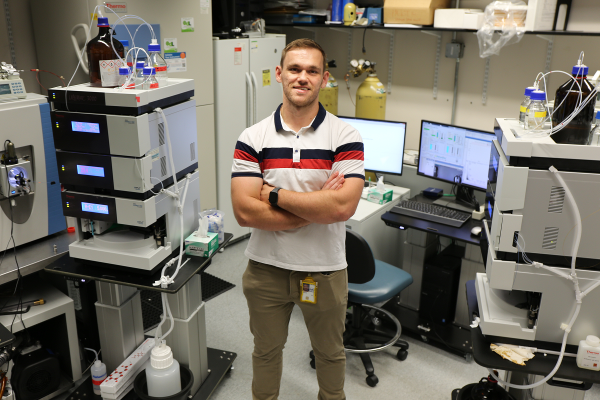 IRP investigator Nathan Basisty stands in front of mass specrometers.