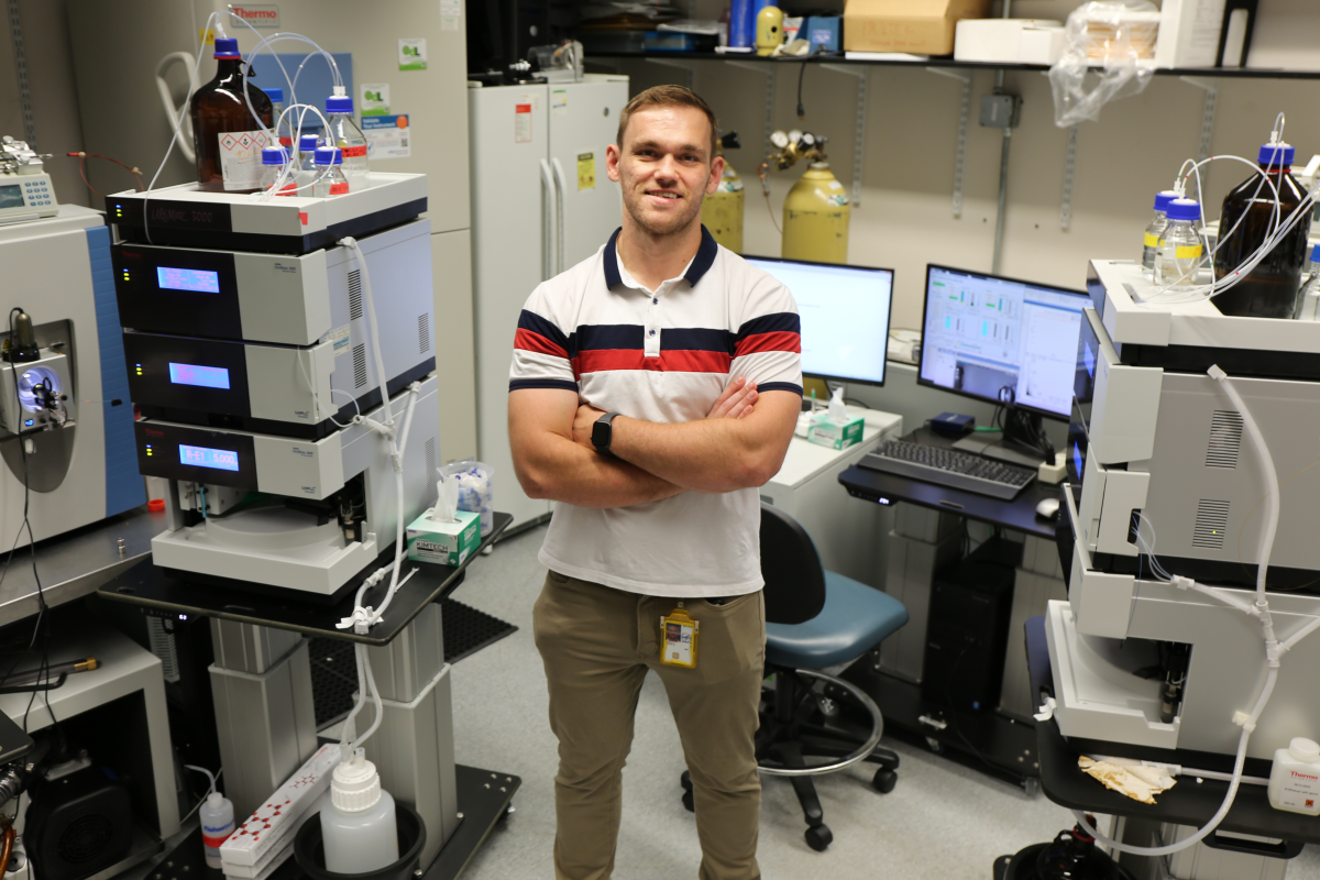 IRP investigator Nathan Basisty stands in front of mass specrometers. 