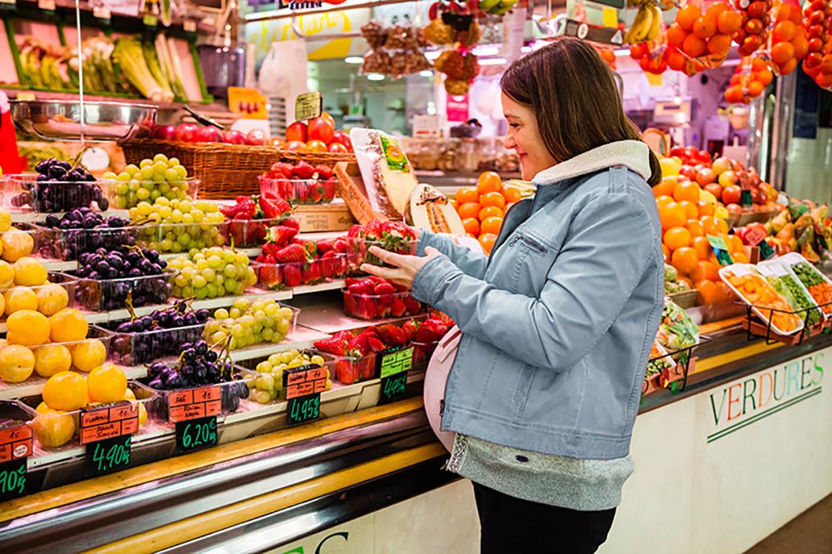 pregnant woman shopping for produce