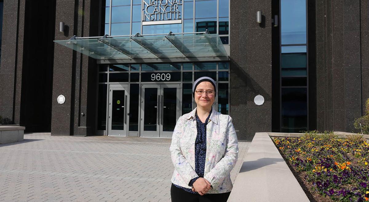 Dr. Shahinaz Gadalla in front of the NCI building in Shady Grove