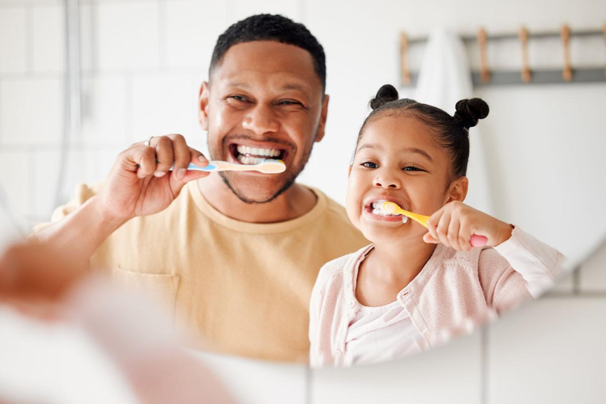 father and doctor brushing their teeth