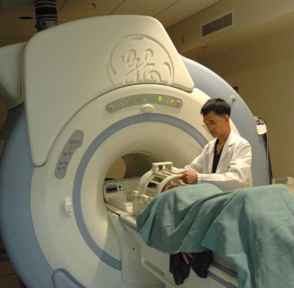 An MRI technician at the NIH prepares a study volunteer for a brain scan