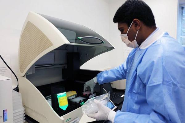 scientist loading a machine in the lab