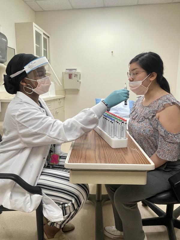 two women doing experiment by smelling test tubes