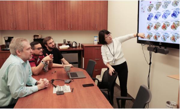 Postdoctoral fellow Soo Hyun Park discusses her experimental results showing patterns of brain activity with the rest of the group (Left to right: Dr. Leopold, Daniel Zaldivar, Will Robinson)