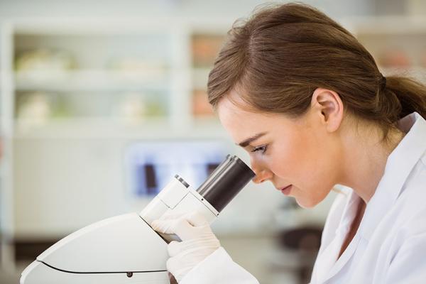 female scientist looking in microscope