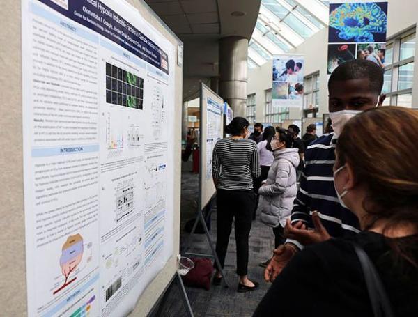 people looking at posters at the 2023 NIH Graduate Student Research Symposium poster session
