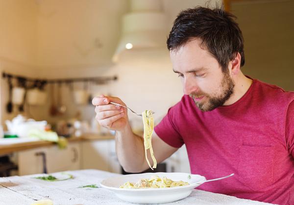 man eating pasta