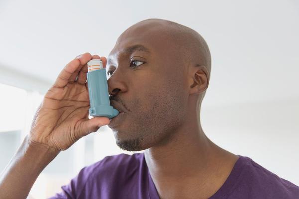 black man using an inhaler