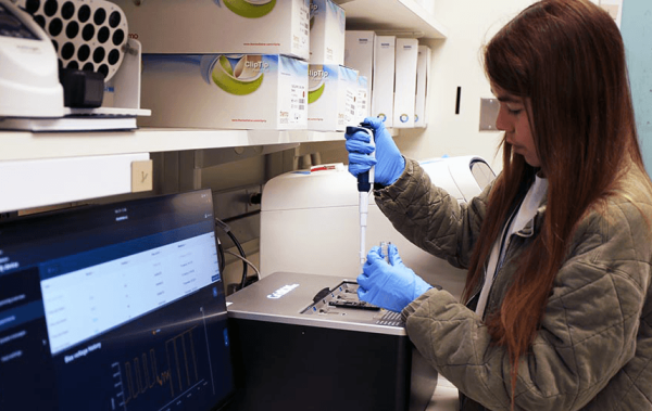 Postbaccalaureate fellow Natalie Asmus places a sample into a ‘long-read sequencer’ machine