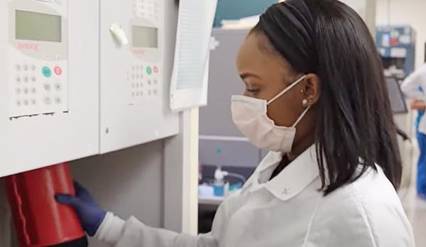 DTM trainee Ashley Collins uses the NIH Clinical Center’s pneumatic tube system to send a blood component to another area of the hospital