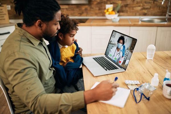 father and child talking to a doctor on their laptop