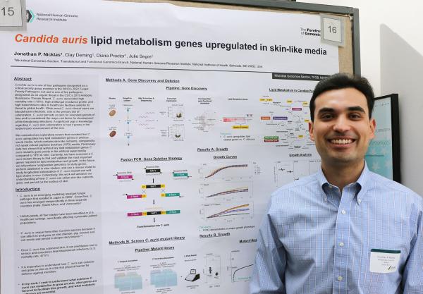 IRP graduate student Jonathan Nicklas poses with his scientific poster