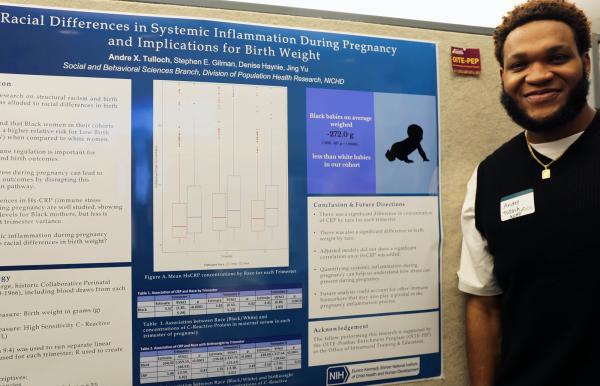 IRP postbaccalaureate fellow Andre Tulloch with his poster at Postbac Poster Day