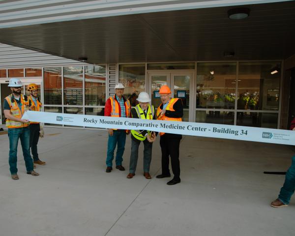 workers cutting ribbon with oversized scissor