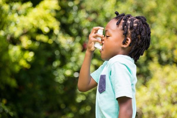 child with asthma using an inhaler