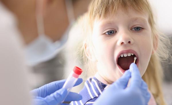 child getting her cheek swabbed for DNA analysis