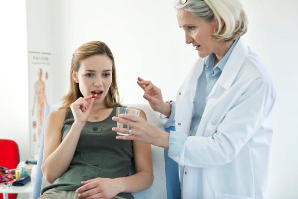 woman with a doctor taking a pill