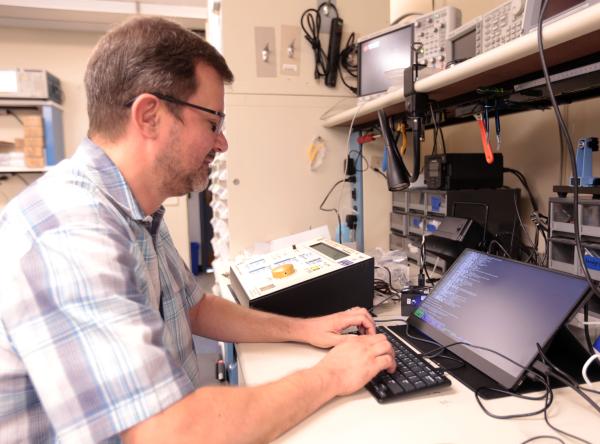 IRP Ideas Lab engineer John Kakareka debugging a machine used for pain research