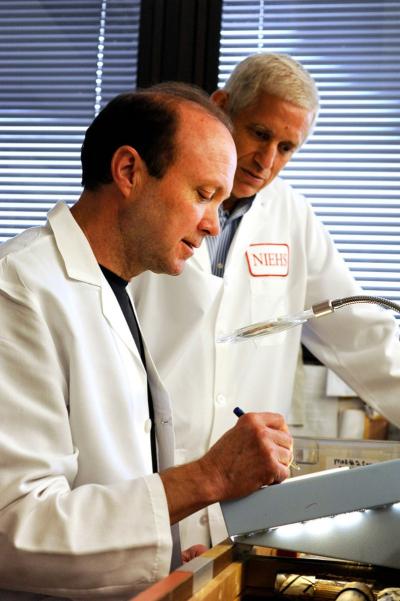 Clark (front) counts yeast cells on a petri dish, while Kunkel observes.