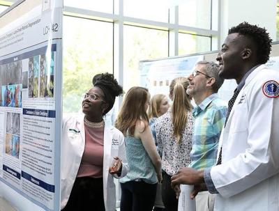 trainees and visitors looking at scientific posters