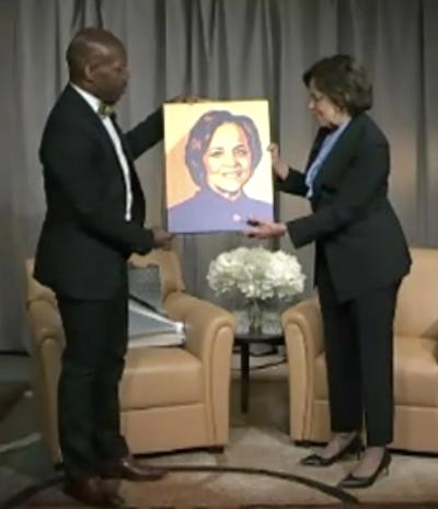 two people holding a portrait of a woman