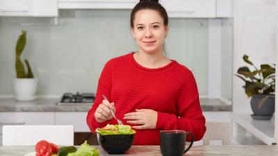 woman wearing red and eating a salad